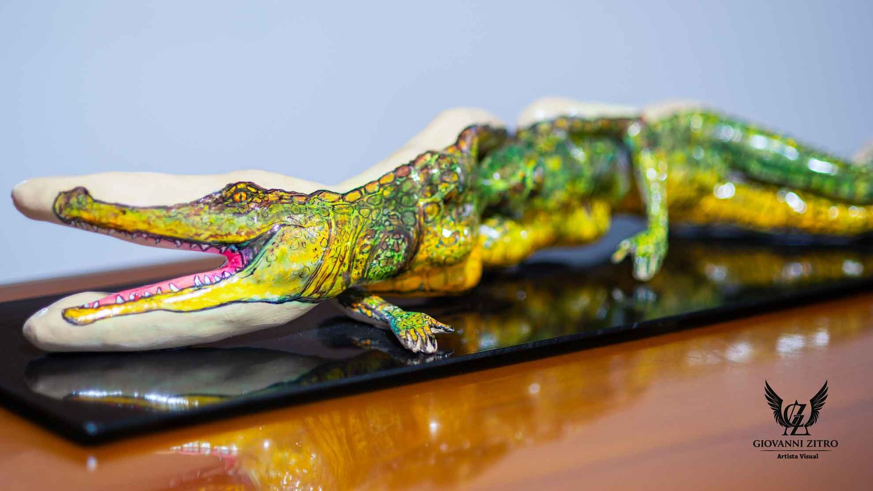 Detalle de una escultura colorida de caimán, con el hocico abierto